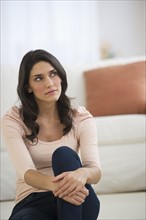 Portrait of young woman sitting on floor.