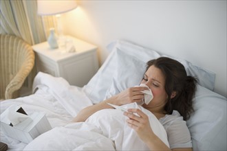 Woman with flu lying in bed.