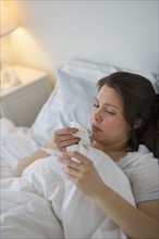 Woman with flu lying in bed.