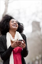 USA, Washington State, Seattle, Cheerful young woman text messaging. Photo : Take A Pix Media