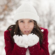 USA, Utah, Lehi, Portrait of young woman blowing snow. Photo : Mike Kemp