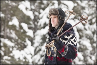 USA, Utah, Salt Lake City, man carrying ski poles. Photo : Mike Kemp