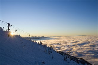 USA, Montana, Whitefish, Ski lift on mountain over clouds. Photo : Noah Clayton