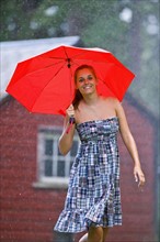 USA, Montana, Whitefish, Portrait of young woman with umbrella in rain . Photo : Noah Clayton