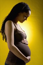 USA, Montana, Lakeside, Pregnant young woman holding belly. Photo : Noah Clayton