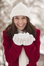 USA, Utah, Lehi, Portrait of young woman holding snow. Photo : Mike Kemp