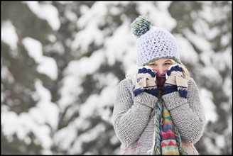 USA, Utah, Salt Lake City, portrait of young woman in winter clothing covering mouth. Photo : Mike