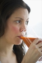 Young woman drinking carrot juice.