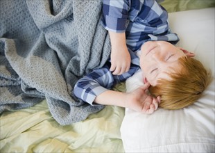 Boy (8-9) sleeping in bed. Photo : Jamie Grill Photography