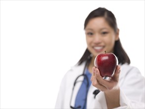 Chinese doctor holding apple. Photo : Dan Bannister
