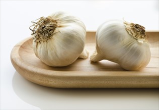 Close up of garlic on wooden tray.