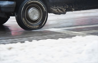 USA, New York, New York City, close up of car's wheels on road in winter.