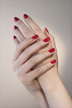 Close up of woman's hands with red nail polish.