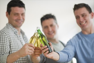 Three men toasting with beer.
