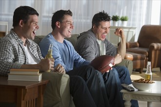 Three men watching television.