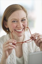 Portrait of woman holding glasses.