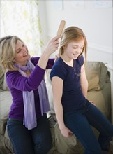 Mother brushing daughter's (10-11) hair. Photo : Jamie Grill Photography