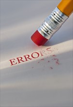 Studio shot of pencil erasing the word errors from piece of paper. Photo : Daniel Grill