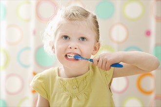 Girl (2-3) brushing teeth. Photo : Mike Kemp