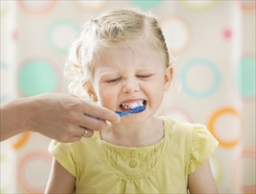 Girl (2-3) having teeth brushed. Photo: Mike Kemp