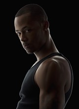 Studio portrait of muscular young man wearing tank top. Photo: Mike Kemp