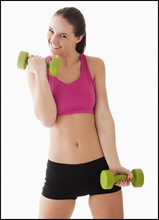 Studio portrait of young woman exercising with hand weights. Photo: Mike Kemp