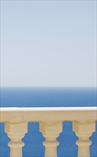 Balustrade overlooking a vivid blue sea and sky backdrop