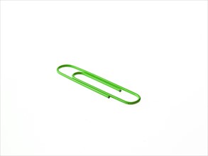Green paper clip on white background. Photo: David Arky