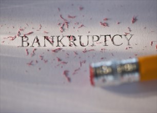 Studio shot of pencil erasing the word bankruptcy from piece of paper. Photo: Daniel Grill