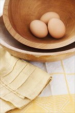 Studio shot of eggs in wooden bowl.