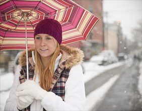 USA, New Jersey, Jersey City, woman with umbrella on street. Photo : Jamie Grill Photography