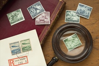 Close up of antique stamp collection and magnifying glass.