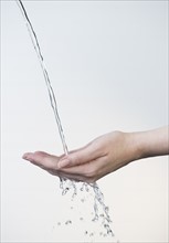 Close up of woman's hands under splashing water.