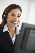 Smiling female customer service representative with headset.