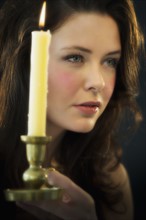 Young woman holding candle.