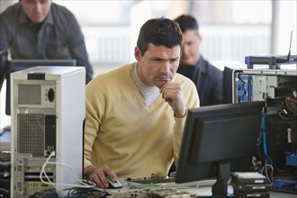 IT Professionals repairing computer in office.