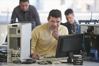 IT Professionals repairing computer in office.