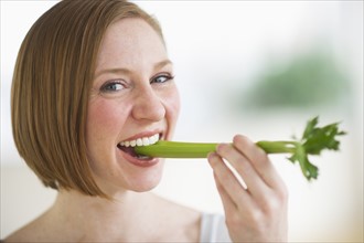 Woman eating fresh celery.