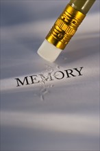 Studio shot of pencil erasing the word memory from piece of paper. Photo: Daniel Grill
