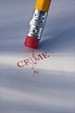 Studio shot of pencil erasing the word crime from piece of paper. Photo : Daniel Grill
