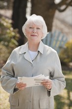 USA, Virginia, Richmond, portrait of senior woman holding bills. Photo: Mark Edward Atkinson