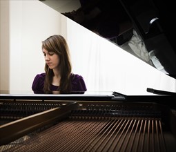 Young woman playing grand piano. Photo: Mike Kemp