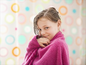 Portrait of girl (10-11) wrapped in towel. Photo: Mike Kemp