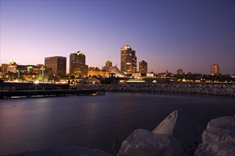 USA, Wisconsin, Milwaukee skyline across lake at dusk. Photo : Henryk Sadura