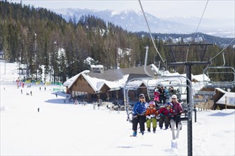 USA, Montana, Whitefish, Family on ski lift. Photo: Noah Clayton