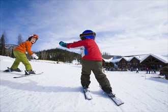 USA, Montana, Whitefish, Boy (4-5) and girl (8-9) skiing. Photo: Noah Clayton