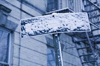 USA, New York City, Arrow sign covered with snow. Photo: Kristin Lee