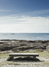 France, Brittany, Morbihan Department, Bench, coastline and ocean. Photo: Jon Boyes