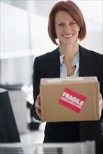 Businesswoman holding box. Photo : Jamie Grill Photography