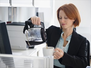Businesswoman pouring coffee. Photo : Jamie Grill Photography